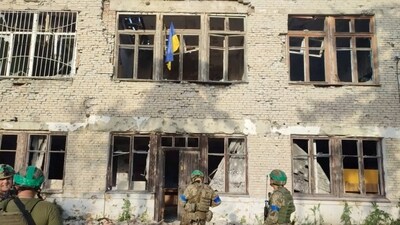 Ukrainian soldiers stand in front of a building with a Ukrainian flag on it, during an operation that claims to liberate the first village amid a counter-offensive, in a location given as Blahodatne, Donetsk Region, Ukraine. (Reuters)