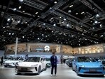 A staff member stands near Nio ET5 cars at its booth at the Auto Shanghai show, in Shanghai, China,