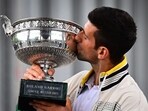 Serbia's Novak Djokovic kisses the Musketeers' Trophy during a photocall after winning the Roland-Garros French Open tennis tournament