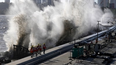 Coastal road workers walk as waves hit the city's waterfront during high tide in the Arabian Sea at Marine Drive in Mumbai, India, Saturday, June 10, 2023. The Bombay Municipal Council is making arrangements to tackle the approach of Cyclone Biparjoy. (AP Photo/Rajanish Kakade) Coastal road workers walk as waves hit the city's waterfront during high tide in the Arabian Sea at Marine Drive in Mumbai, India, Saturday, June 10, 2023. The Bombay Municipal Council is making arrangements to tackle the approach of Cyclone Biparjoy. (AP Photo/Rajanish Kakade)