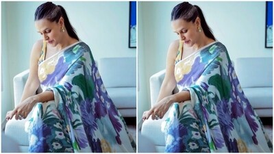 Neha played muse to fashion designer house Yam India and picked the white silk saree featuring floral patterns in shades of yellow, blue, violet and green. (Instagram/@nehadhupia) Neha played muse to fashion designer house Yam India and picked the white silk saree featuring floral patterns in shades of yellow, blue, violet and green. (Instagram/@nehadhupia)