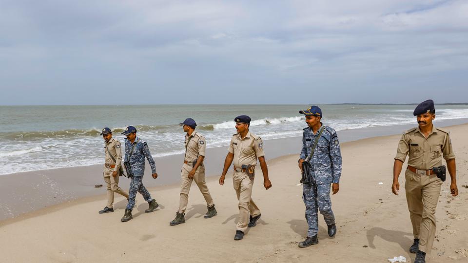 Gujarat and marine police personnel patrol the Mandvi beach in Kutch district ahead of the landfall of Cyclone Biparjoy on Monday. (PTI)
