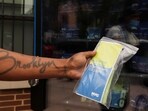 A person holds a pack of fentanyl test strips dispersed from a vending machine that offers free naloxone kits, fentanyl test strips and birth control packs, with using only zip codes, in Brooklyn, New York, US.