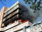 Smoke and flames billow out of the Satpura Bhawan that caught a massive fire, in Bhopal on Monday. (ANI)