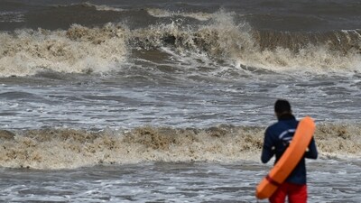 A lifeguard keeps watch during a red flag alert due to rough seas and high tidal waves hit Juhu beach in Mumbai on June 13, ( Punit Paranjpe / AFP) A lifeguard keeps watch during a red flag alert due to rough seas and high tidal waves hit Juhu beach in Mumbai on June 13, ( Punit Paranjpe / AFP)