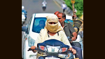 A commuter protects her face with a cloth from the searing heat in Ludhiana on Tuesday. (Gurpreet Singh/HT)