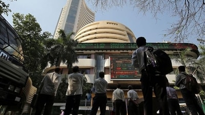 People look at a screen displaying the Sensex results on the facade of the Bombay Stock Exchange (BSE) building in Mumbai. (File Photo)