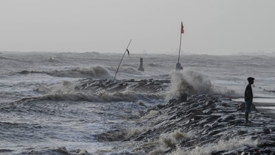 A boy walks as high tide waves hit the Arabian Sea coast at Juhu Koliwada in Mumbai, India, Monday, June 12, 2023. (AP)