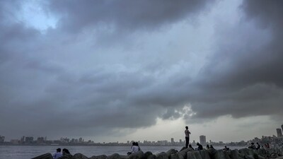 People visit the seafront as monsoon clouds cover the city skyline. (PTI) People visit the seafront as monsoon clouds cover the city skyline. (PTI)