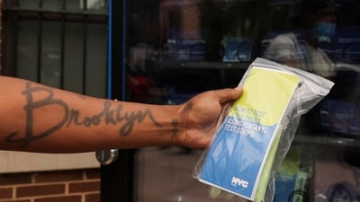 A person holds a pack of fentanyl test strips dispersed from a vending machine that offers free naloxone kits, fentanyl test strips and birth control packs, with using only zip codes, in Brooklyn, New York, US. (REUTERS)
