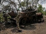 Ukrainian service members check a destroyed Russian a BMP-2 infantry fighting vehicle, amid Russia's attack on Ukraine. 