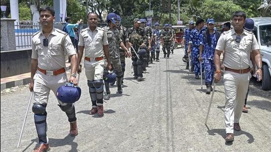 Police personnel walk past during a route march ahead of the state Panchayat poll, in Nadia. (PTI)