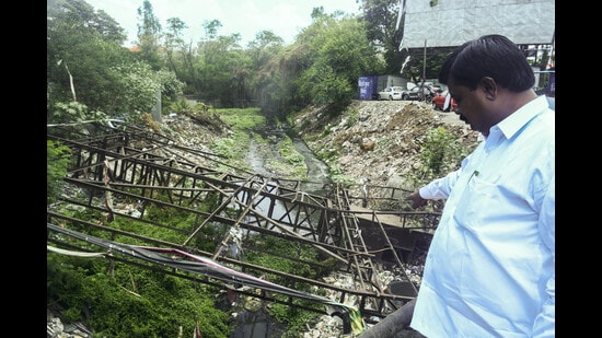 Pramod Devikar shows a nullah in bad condition at Ramwadi in Pune on Wednesday. (SHANKAR NARAYAN/ HT)
