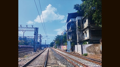One can see the grey Vile Parle building from the railway tracks. A portion of it housing three residents juts out and is thus perilously close to the sixth rail line. (HT Photo)