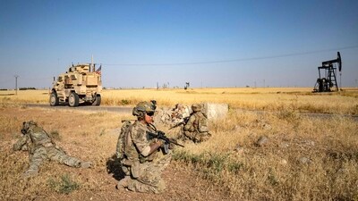 US troops take position as they patrol near an oil field in al-Qahtaniyah in Syria's northeastern Hasakah province. (AFP)