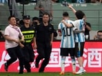Security officers pursue a fan as he hugs Argentina's Lionel Messi friendly against Australia Security officers pursue a fan as he hugs Argentina's Lionel Messi friendly against Australia
