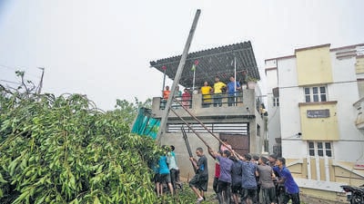 Workers erect a pole to restore electricity in Kutch district of Gujarat. (AP)