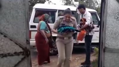 Screengrab of video showing Gujarat cop carrying the four-day-old baby in her arms during rescue operation as cyclone Biparjoy hit state. (Mulubhai Bera/Twitter)