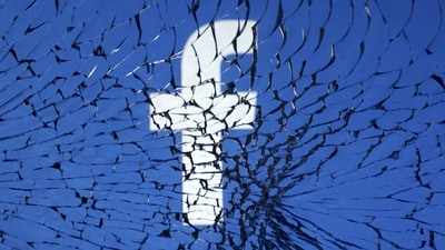 Facebook logo is seen through broken glass in this illustration, (REUTERS)