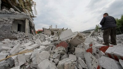 A man stands on debris of a building heavily damaged by a Russian military strike. (REUTERS)