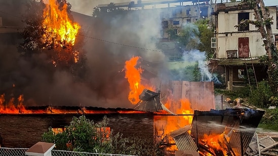 Flames and smoke billow out after an old warehouse owned by a retired bureaucrat set ablaze amid violence, in Imphal East district on Friday. (PTI)