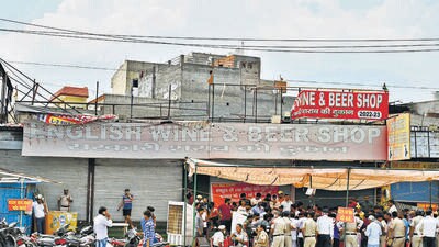 Residents gather outside the liquor shop on NH-48 on Sunday. (Parveen Kumar/ HT) Residents gather outside the liquor shop on NH-48 on Sunday. (Parveen Kumar/ HT)