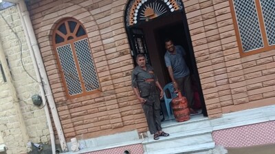 Worker who delivered the gas cylinder along with the consumer at in front of his residence. (Twitter/Hardeep Singh Puri)