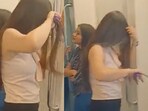 Woman uses hair straightener in Delhi Metro. Woman uses hair straightener in Delhi Metro.