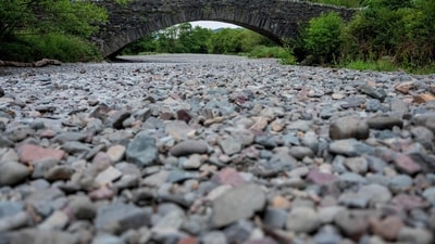 People cross a bridge over the dry river bed, (Reuters)