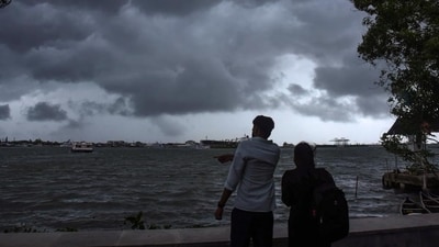 People enjoy weather as dark clouds cover the city skyline during the onset of monsoon over Kerala a week later than usual, in Kochi (PTI) People enjoy weather as dark clouds cover the city skyline during the onset of monsoon over Kerala a week later than usual, in Kochi (PTI)