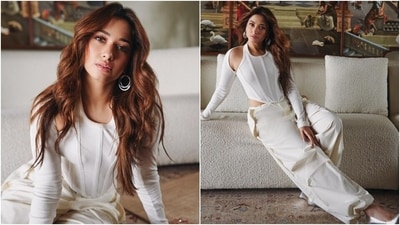 Tamannaah styled the top with matching arm warmers featuring full-length sleeves and a ribbed pattern. She completed the outfit with matching white cotton cargo pants featuring a drawstring waist closure, cinched hem, a baggy silhouette, and side pockets. (Instagram) Tamannaah styled the top with matching arm warmers featuring full-length sleeves and a ribbed pattern. She completed the outfit with matching white cotton cargo pants featuring a drawstring waist closure, cinched hem, a baggy silhouette, and side pockets. (Instagram)