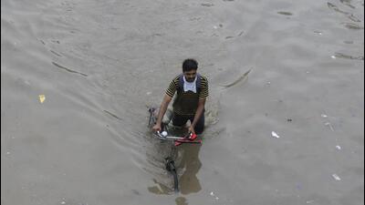 A cyclist wade through a waterlogged road in Narsinghpur village in Gurugram. (Parveen Kumar/ HT) A cyclist wade through a waterlogged road in Narsinghpur village in Gurugram. (Parveen Kumar/ HT)