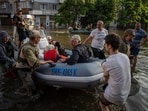 Ukrainian servicemen arrive by boat with civilians during evacuation from the flooded Kardashynka village. Ukrainian servicemen arrive by boat with civilians during evacuation from the flooded Kardashynka village.