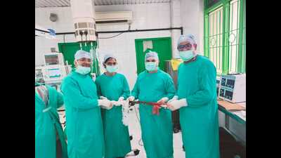 Doctors holding the iron rod taken out of the chest of a bus driver whose life they saved. (Sourced)