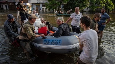 Ukrainian servicemen arrive by boat with civilians during evacuation from the flooded Kardashynka village. (AP) Ukrainian servicemen arrive by boat with civilians during evacuation from the flooded Kardashynka village. (AP)
