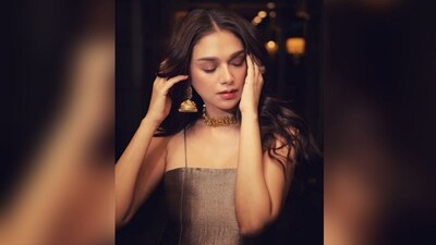 Aditi opted for a natural makeup look with nude eyeshadow, winged eyeliner, mascara-coated lashes, contoured cheeks, and a pink lipstick. Her curly hair was left open with a middle partition, completing her glamorous appearance. (Instagram/@sanamratansi ) Aditi opted for a natural makeup look with nude eyeshadow, winged eyeliner, mascara-coated lashes, contoured cheeks, and a pink lipstick. Her curly hair was left open with a middle partition, completing her glamorous appearance. (Instagram/@sanamratansi )