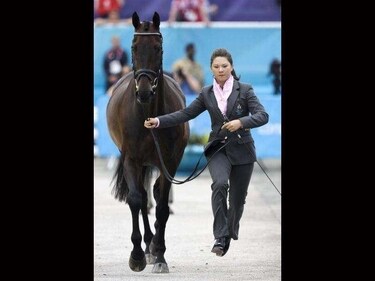 Thailand's Nina Ligon runs with her horse Butts Leon during horse inspection for the equestrian eventing competition at Greenwich Park, the site for the equestrian and modern pentathlon events at the 2012 Summer Olympics in London. (AP Photo/Markus Schreiber)