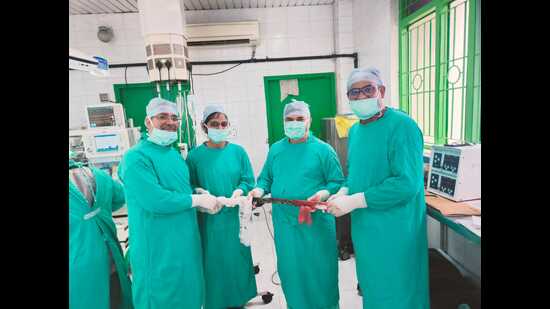 Doctors holding the iron rod taken out of the chest of a bus driver whose life they saved. (Sourced)