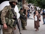 A local resident walks past members of Wagner group in Rostov-on-Don, on Saturday.