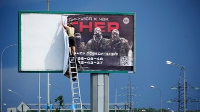 A man takes down the poster with writing reading “Join us at Wagner”, seen above a highway on the outskirts of St. Petersburg, Russia, Saturday. The Russian defence ministry, however, refuted Prigozhin's claims and urged Wagner boss to halt the rebellion. They also raised concern over the advantage to Ukrainian troops due to the internal discord within Russia that would ready them for an assault near the eastern hotspot of Bakhmut. (AP) A man takes down the poster with writing reading “Join us at Wagner”, seen above a highway on the outskirts of St. Petersburg, Russia, Saturday. The Russian defence ministry, however, refuted Prigozhin's claims and urged Wagner boss to halt the rebellion. They also raised concern over the advantage to Ukrainian troops due to the internal discord within Russia that would ready them for an assault near the eastern hotspot of Bakhmut. (AP)