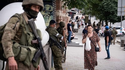 A local resident walks past members of Wagner group in Rostov-on-Don, on Saturday. (AFP) A local resident walks past members of Wagner group in Rostov-on-Don, on Saturday. (AFP)
