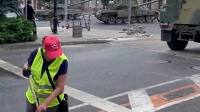 A man continues to clean the street while the armoured cars can be seen streaming by the roads of the city. (Twitter/ @Osinttechnical) A man continues to clean the street while the armoured cars can be seen streaming by the roads of the city. (Twitter/ @Osinttechnical)
