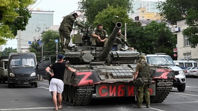A man speaks with fighters of Wagner private mercenary group deployed in a street near the headquarters of the Southern Military District in the city of Rostov-on-Don, Russia. (REUTERS)