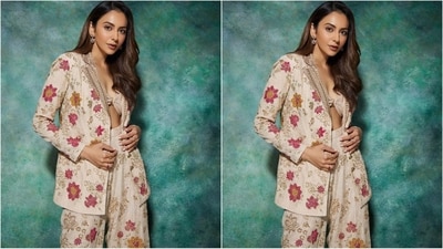 The actress's attire comprises a captivating three-piece set, including a bralette with a unique twisted knot style top, a beige-colored blazer, and flared pants adorned with exquisite floral embroidery in shades of pink and golden. (Instagram/@rakulpreet) The actress's attire comprises a captivating three-piece set, including a bralette with a unique twisted knot style top, a beige-colored blazer, and flared pants adorned with exquisite floral embroidery in shades of pink and golden. (Instagram/@rakulpreet)