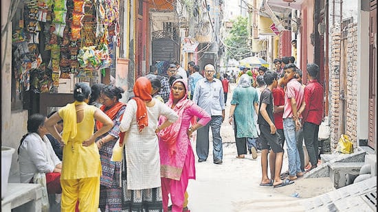 Locals gather around the residence of the 20-year-old victim, Rahul, at Brij Puri in New Delhi on Saturday. (Sanchit Khanna/HT PHOTO)