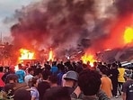 People at the site of fire in Manipur. (PTI) People at the site of fire in Manipur. (PTI)