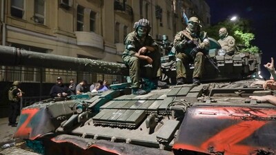 Membes of the Wagner Group military company sit atop of a tank on a street in Rostov-on-Don. (AP)