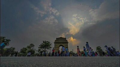 People enjoy a cloudy evening near India Gate lawns, in New Delhi on Monday. (Raj K Raj/HT)