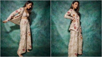 Rakul's outfit features a nude-coloured strapless bralette with a plunging sweetheart neckline and a coordinated multi-coloured floral printed suit set in a beige shade. While the jacket has gota patti-embroidered notch lapel collars, full-length sleeves, an open front, and a relaxed silhouette, the pants feature a high-rise waist and a flared hem. (Instagram) Rakul's outfit features a nude-coloured strapless bralette with a plunging sweetheart neckline and a coordinated multi-coloured floral printed suit set in a beige shade. While the jacket has gota patti-embroidered notch lapel collars, full-length sleeves, an open front, and a relaxed silhouette, the pants feature a high-rise waist and a flared hem. (Instagram)