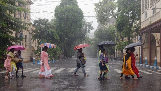 Students along with their parents cover themselves with umbrellas and raincoats as they enjoy their return during rainfall, in Kolkata on Sunday. (ANI) Students along with their parents cover themselves with umbrellas and raincoats as they enjoy their return during rainfall, in Kolkata on Sunday. (ANI)